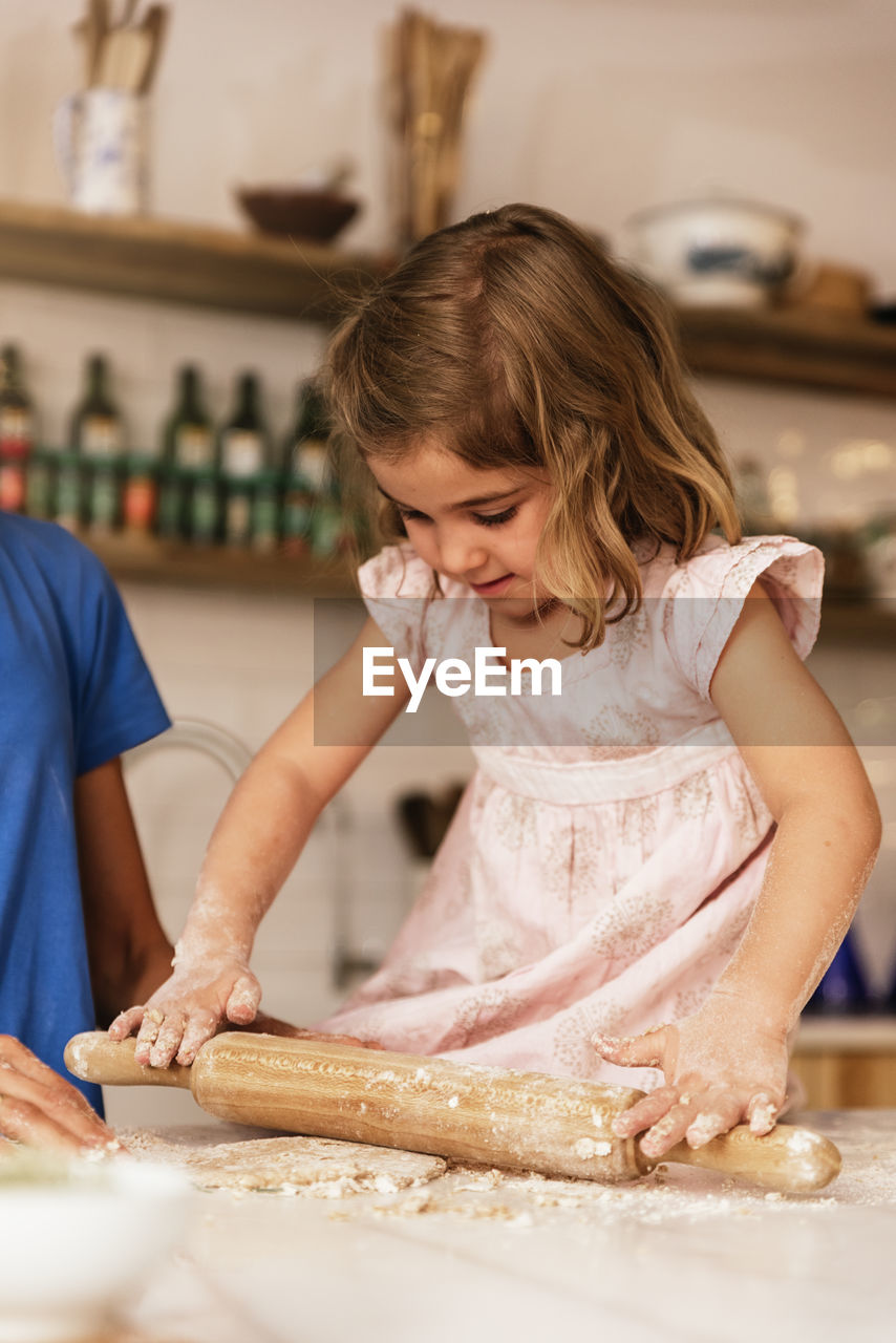 CLOSE-UP OF GIRL EATING FOOD IN KITCHEN AT HOME