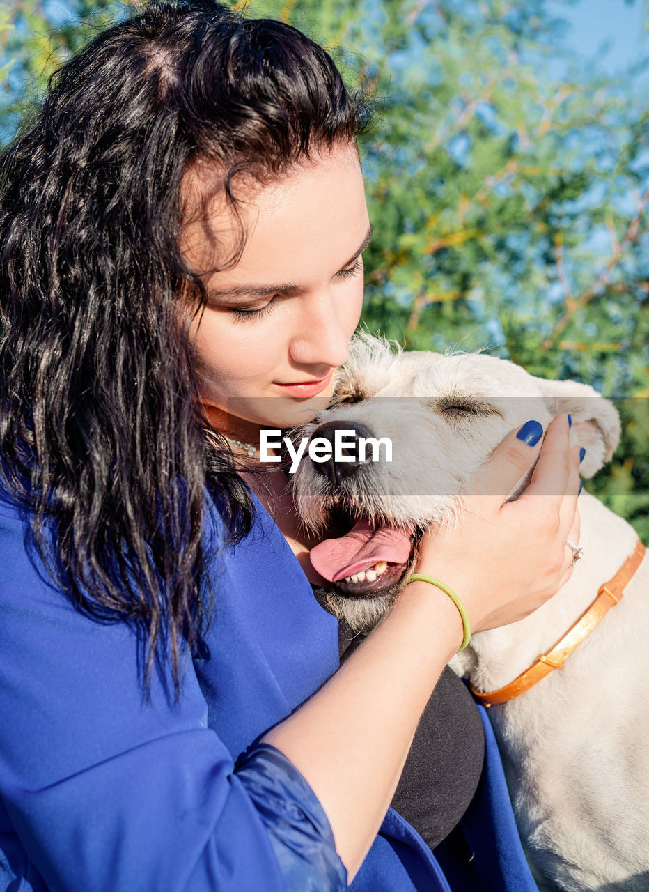 Midsection of woman holding her dog outside 