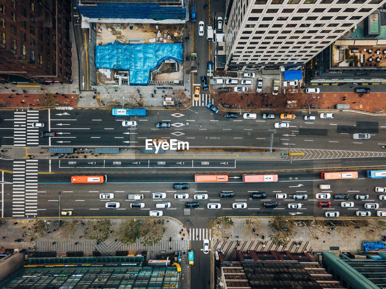 Drone view of cars on road amidst buildings in city