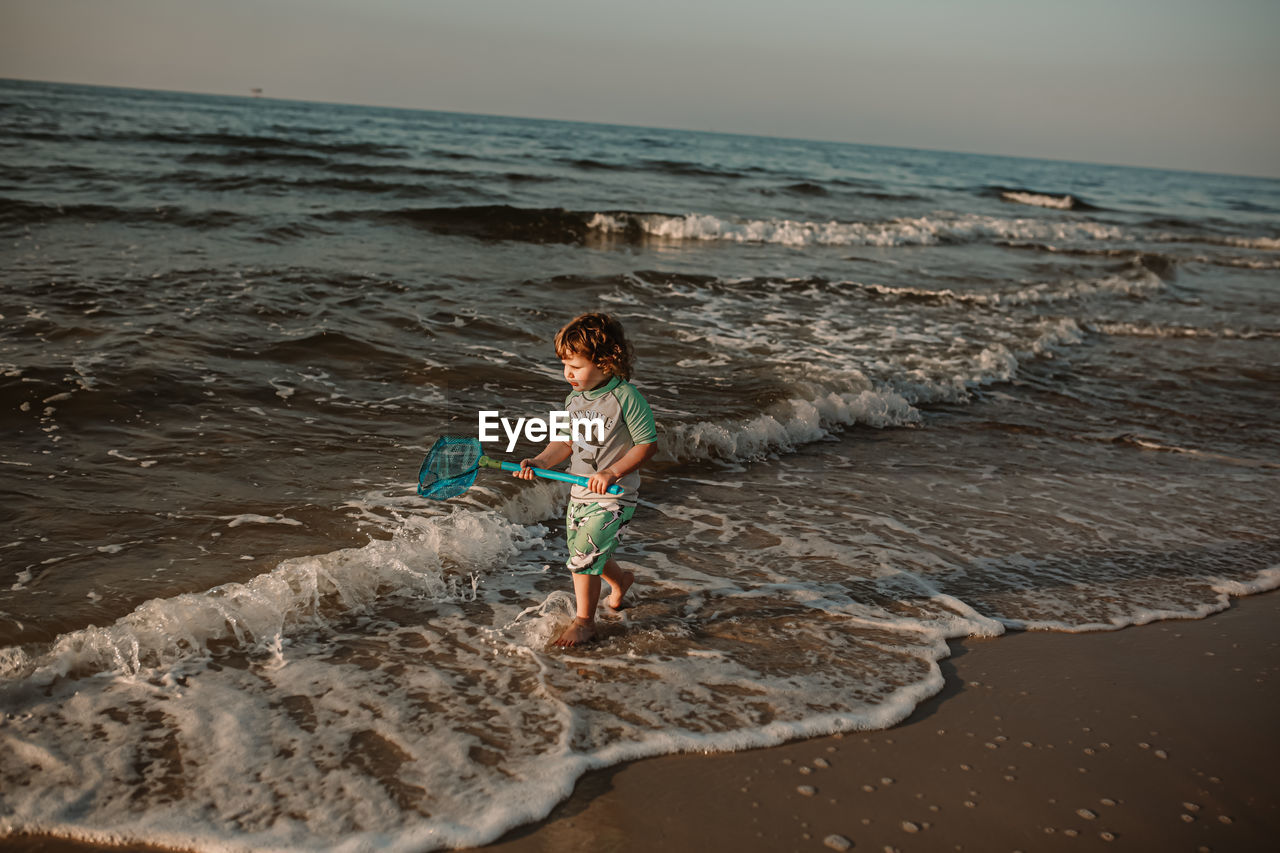 Boy on beach at sunrise