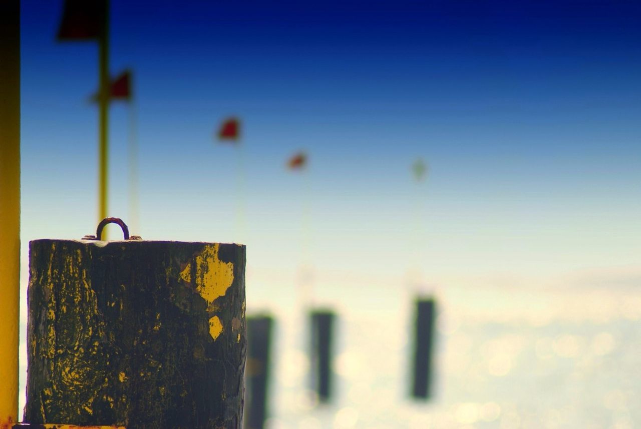 CLOSE-UP OF WOODEN POST AGAINST THE SKY