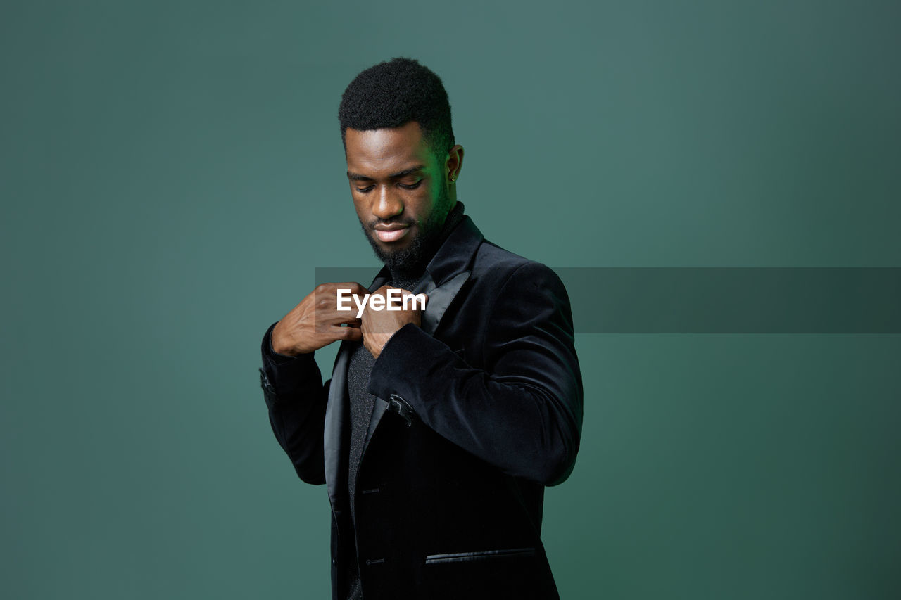 side view of young man suffering from camera against black background