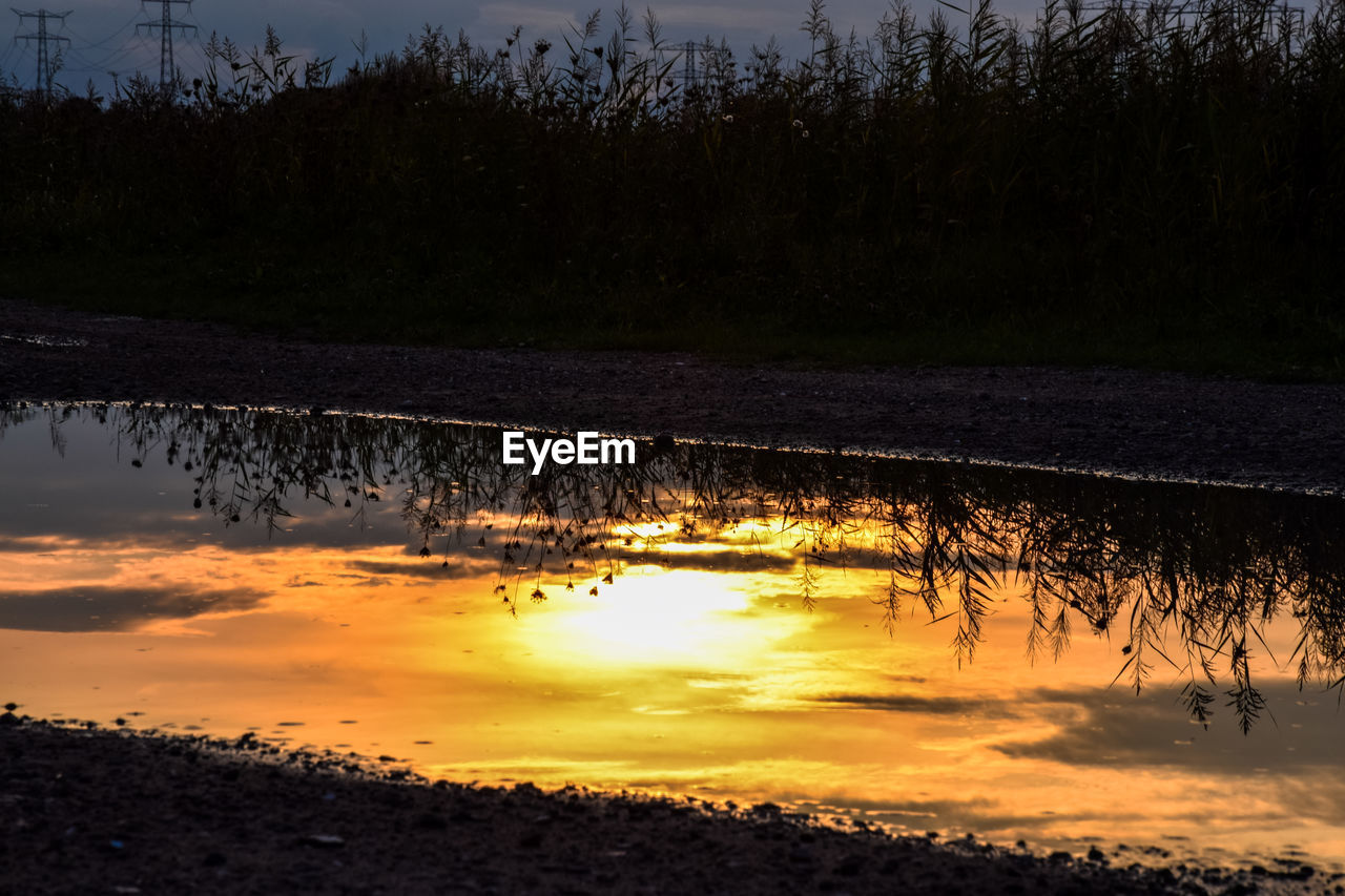 CLOSE-UP OF REFLECTION IN LAKE AGAINST SKY