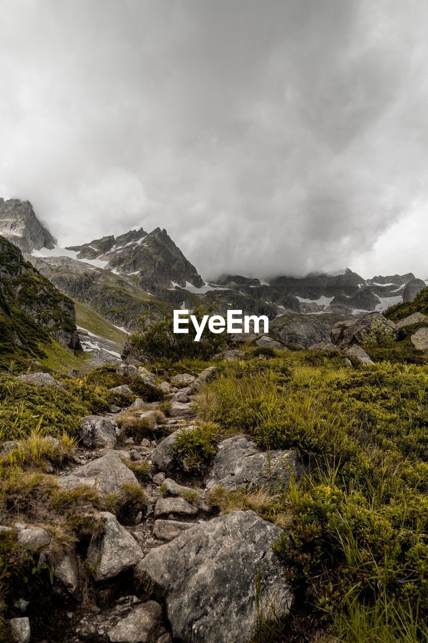 Scenic view of landscape and mountains against cloudy sky