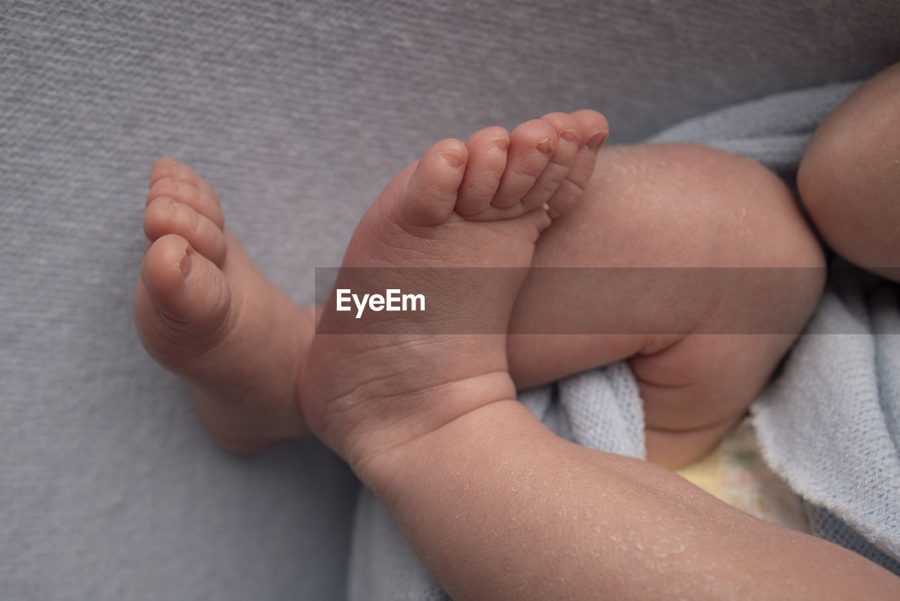 HIGH ANGLE VIEW OF BABY FEET ON FLOOR