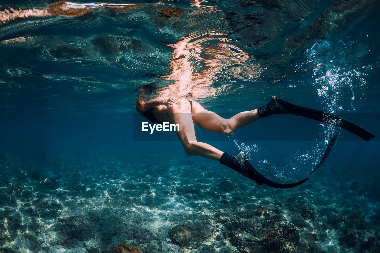 low section of woman swimming in sea