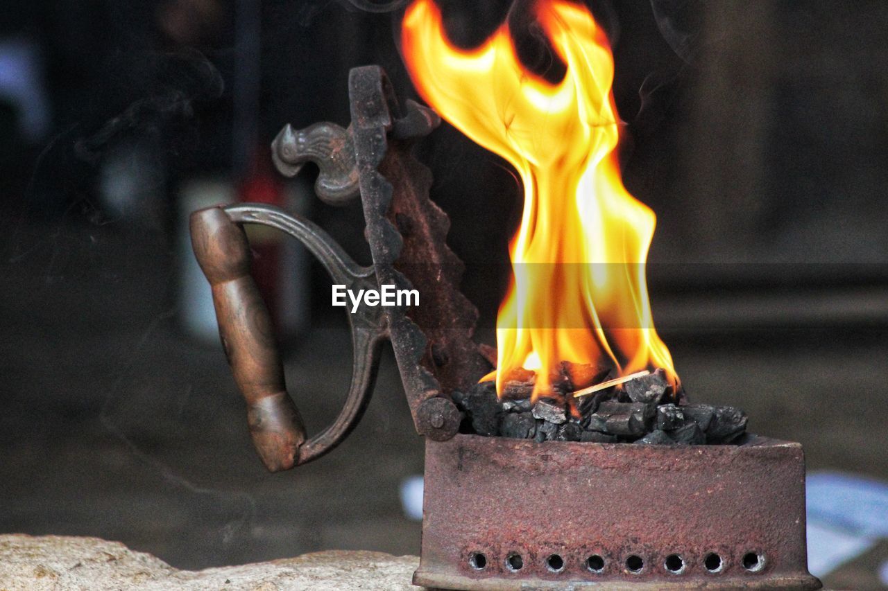 Close-up of burning candles and charcoal iron