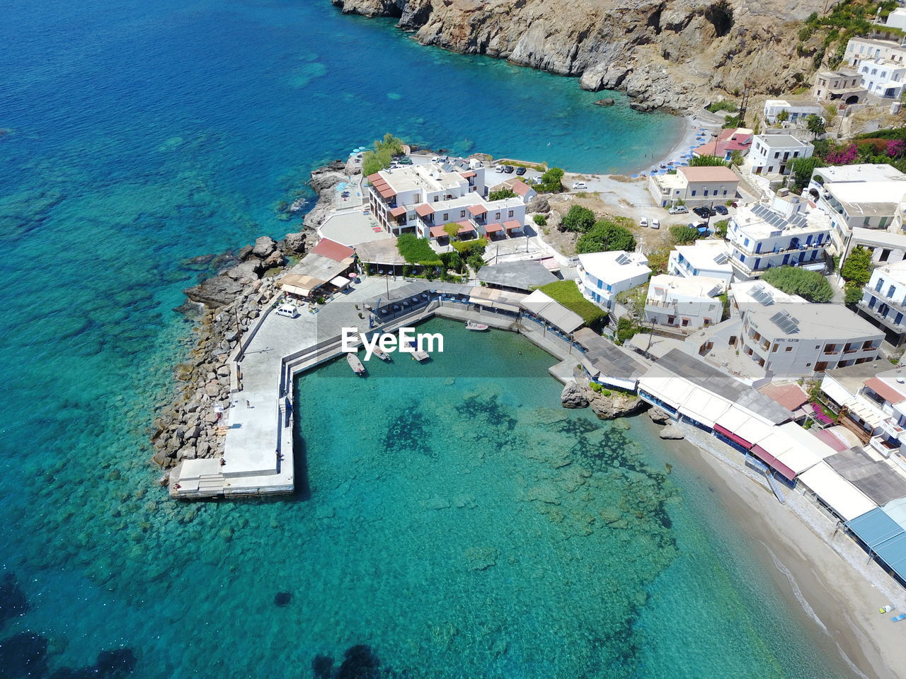 HIGH ANGLE VIEW OF SWIMMING POOL WITH SEA IN BACKGROUND
