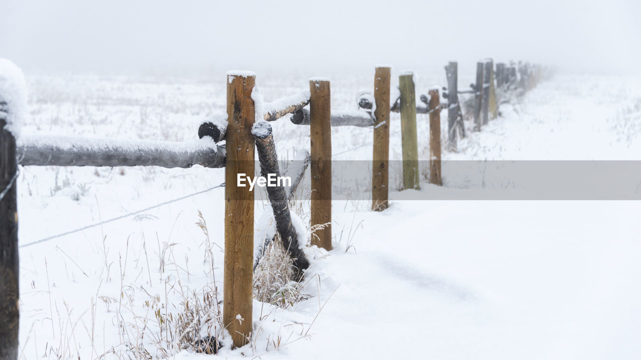 FENCE ON SNOW COVERED FIELD