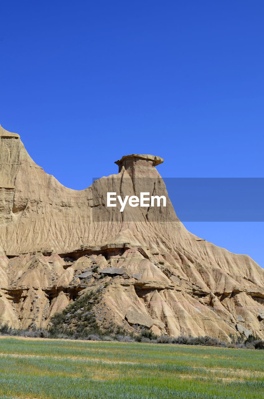 ROCK FORMATIONS ON LANDSCAPE AGAINST BLUE SKY