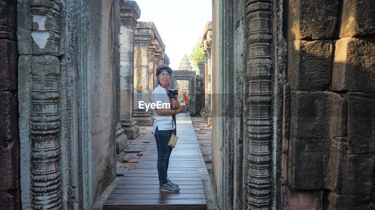 PORTRAIT OF YOUNG MAN AGAINST HISTORIC BUILDING