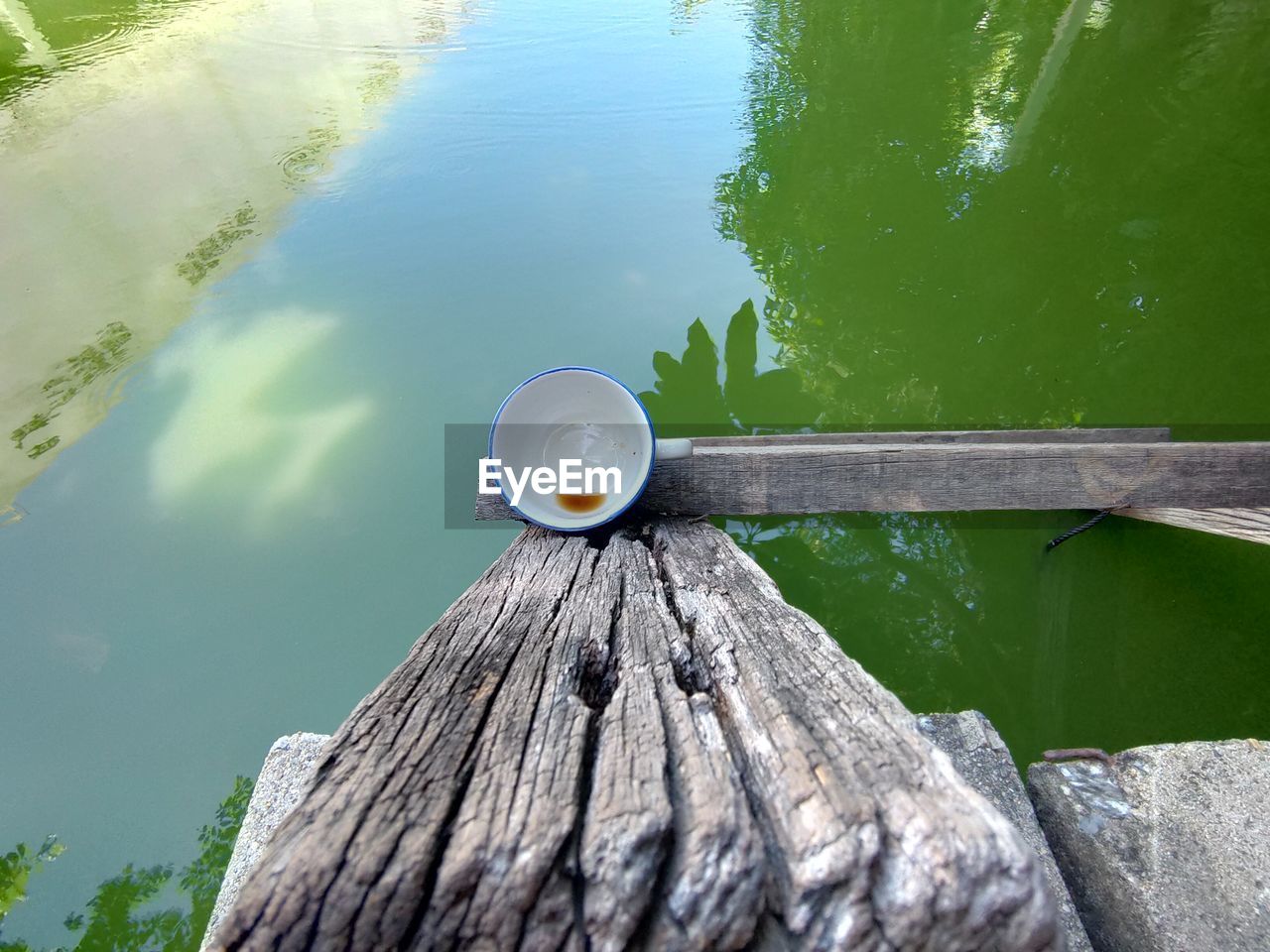 HIGH ANGLE VIEW OF WOODEN POST ON PIER