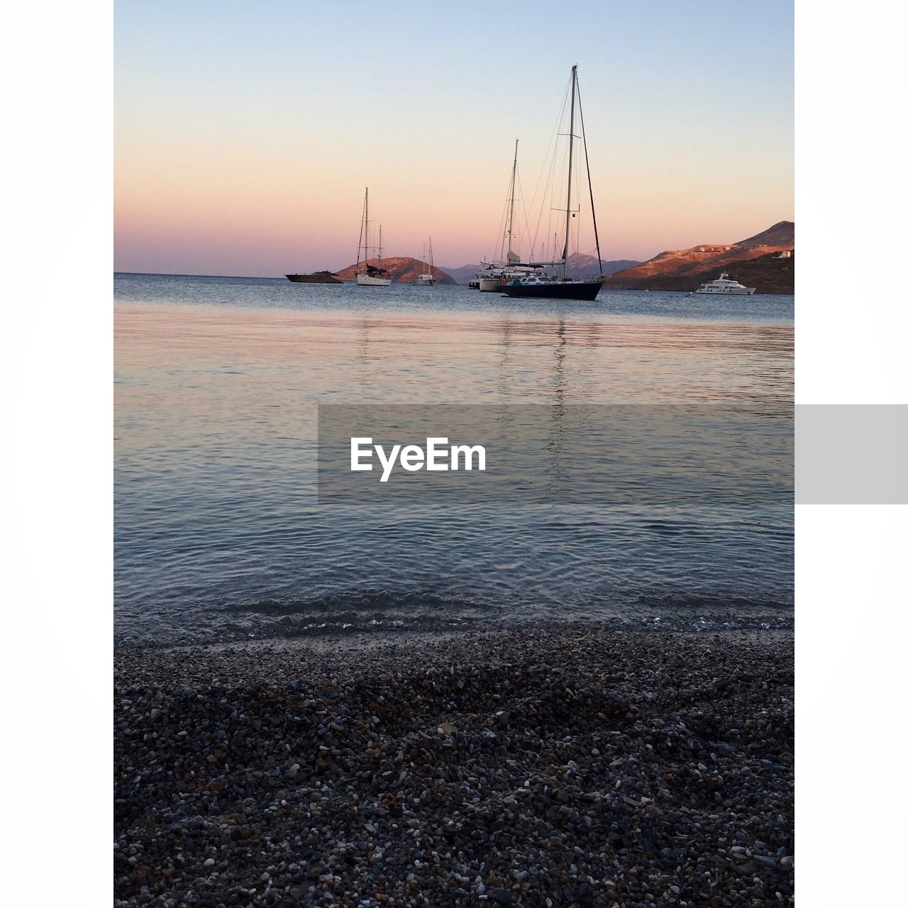 VIEW OF BOATS IN SEA AT SUNSET