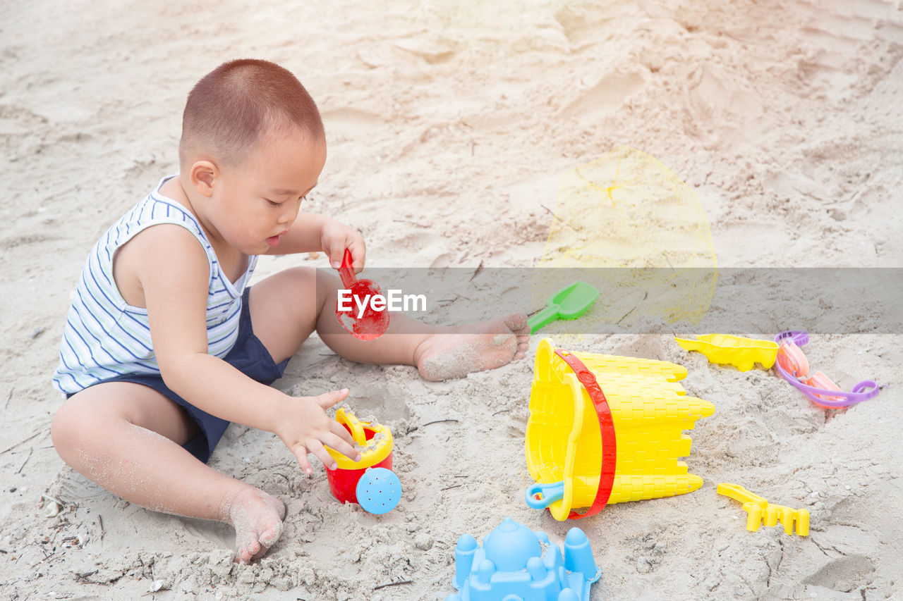 High angle view of boy playing with toy on beach