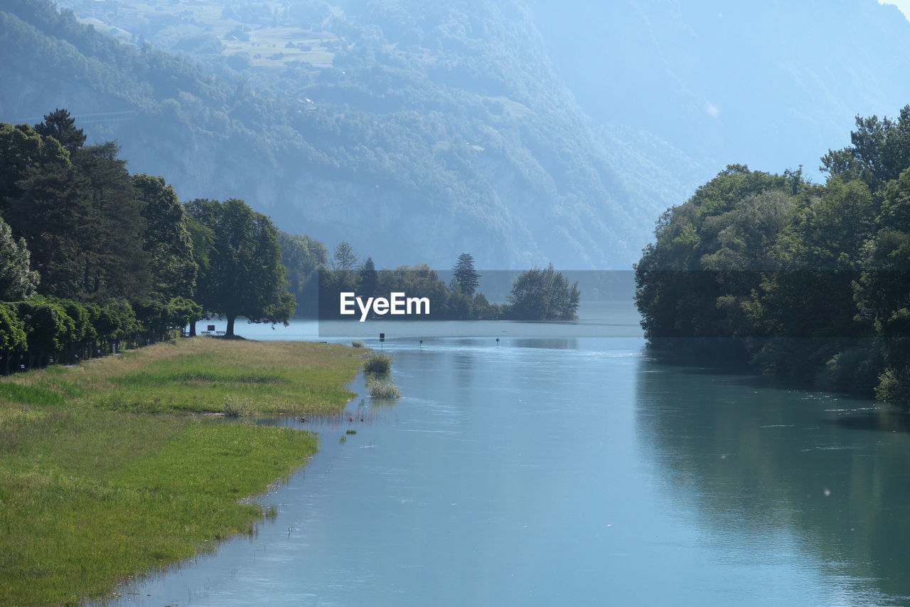 Scenic view of lake by trees against sky