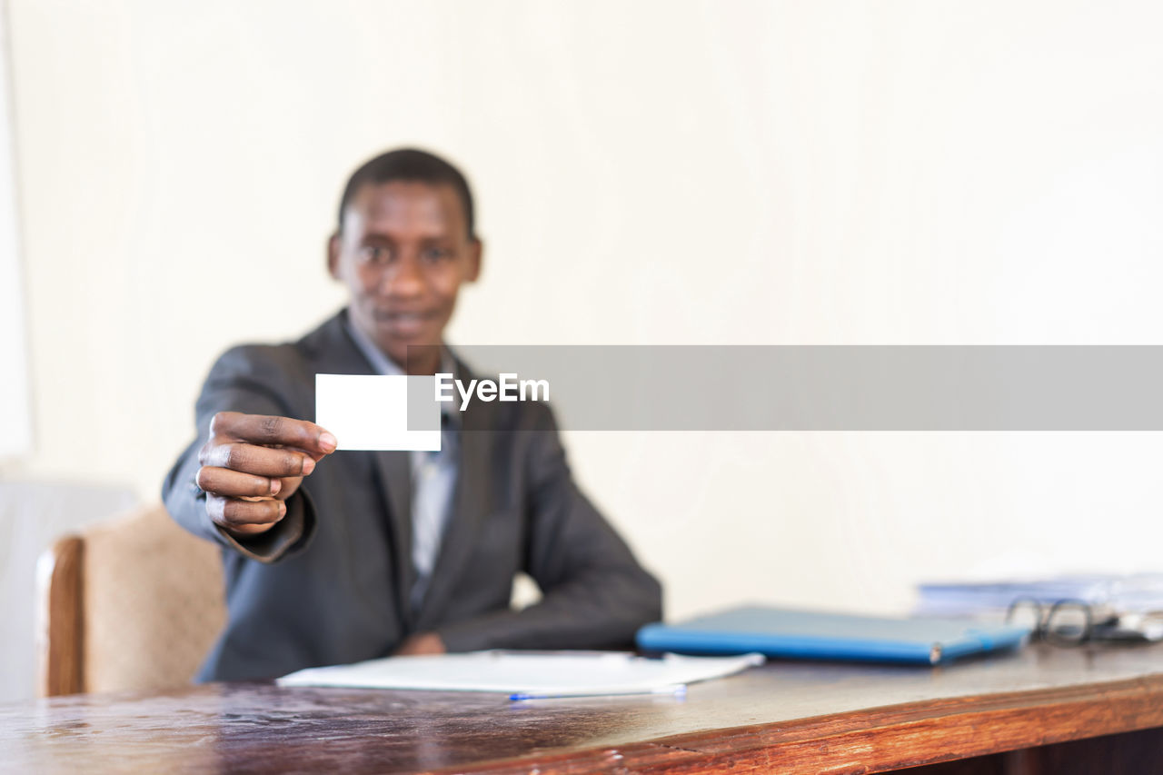 PORTRAIT OF MAN HOLDING SMART PHONE