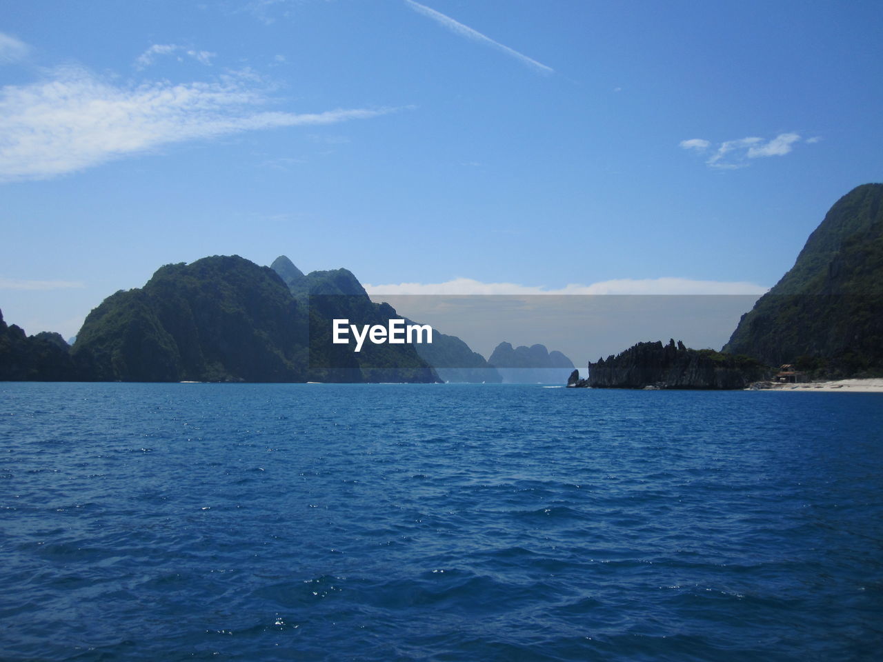 Scenic view of sea and mountains against sky