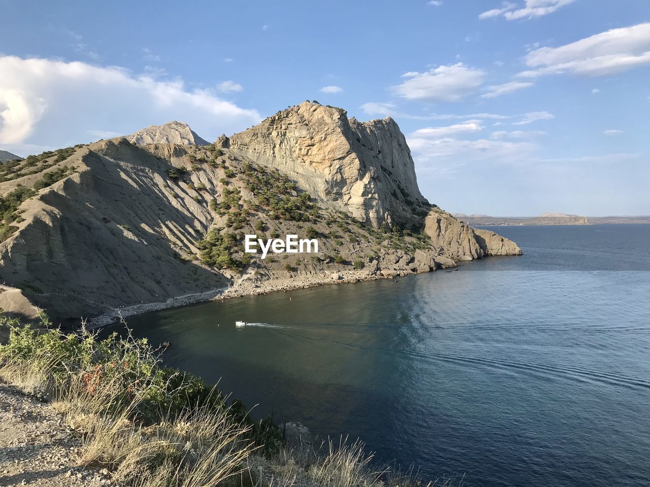 Scenic view of sea and mountains against sky