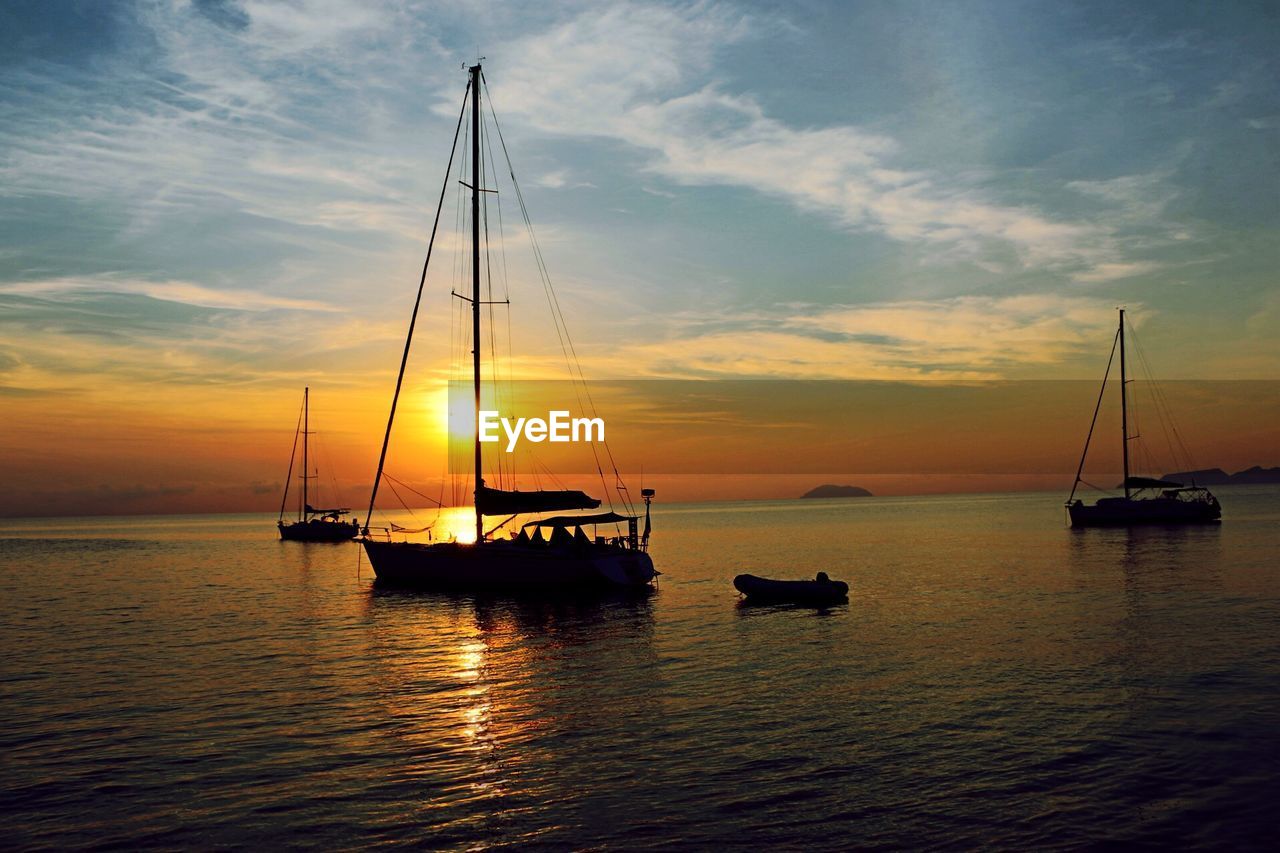 Sailboat on sea against sky during sunset