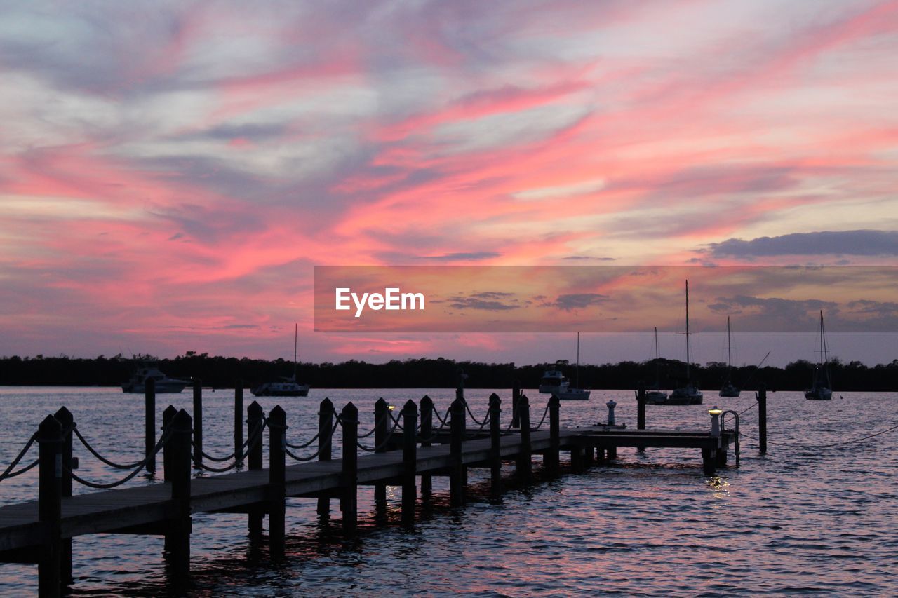 Pier on lake against cloudy sky