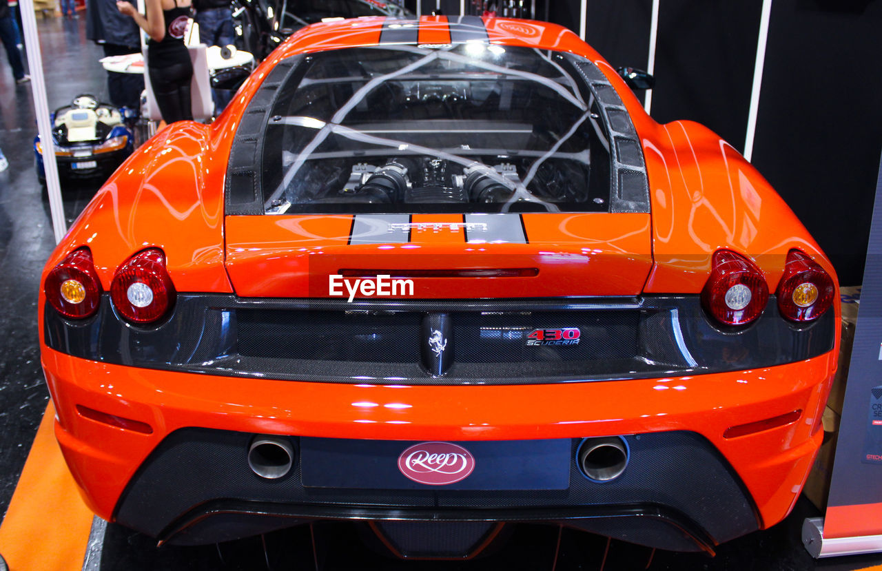 CLOSE-UP OF ORANGE CAR ON ROAD