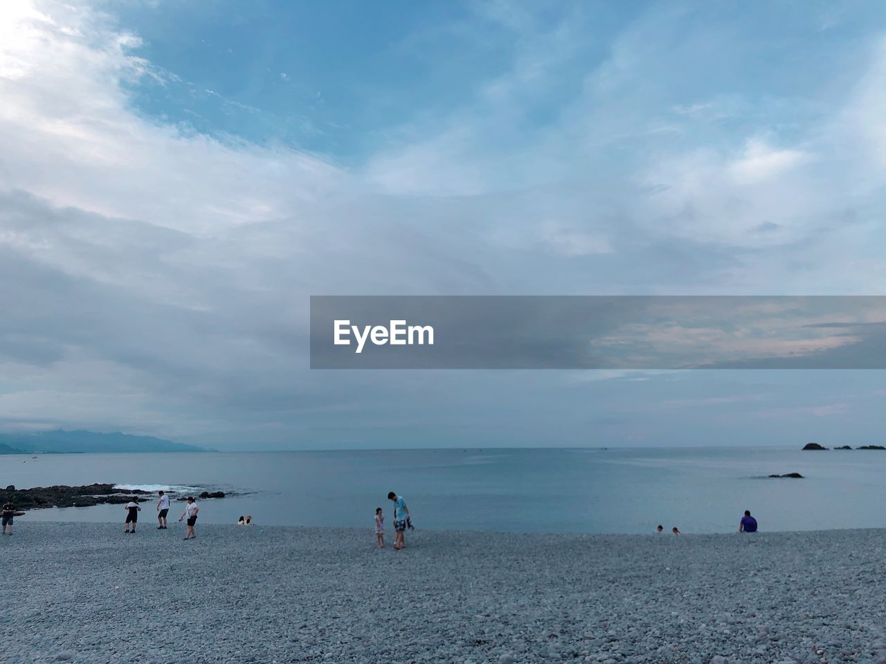 GROUP OF PEOPLE ON BEACH AGAINST SKY