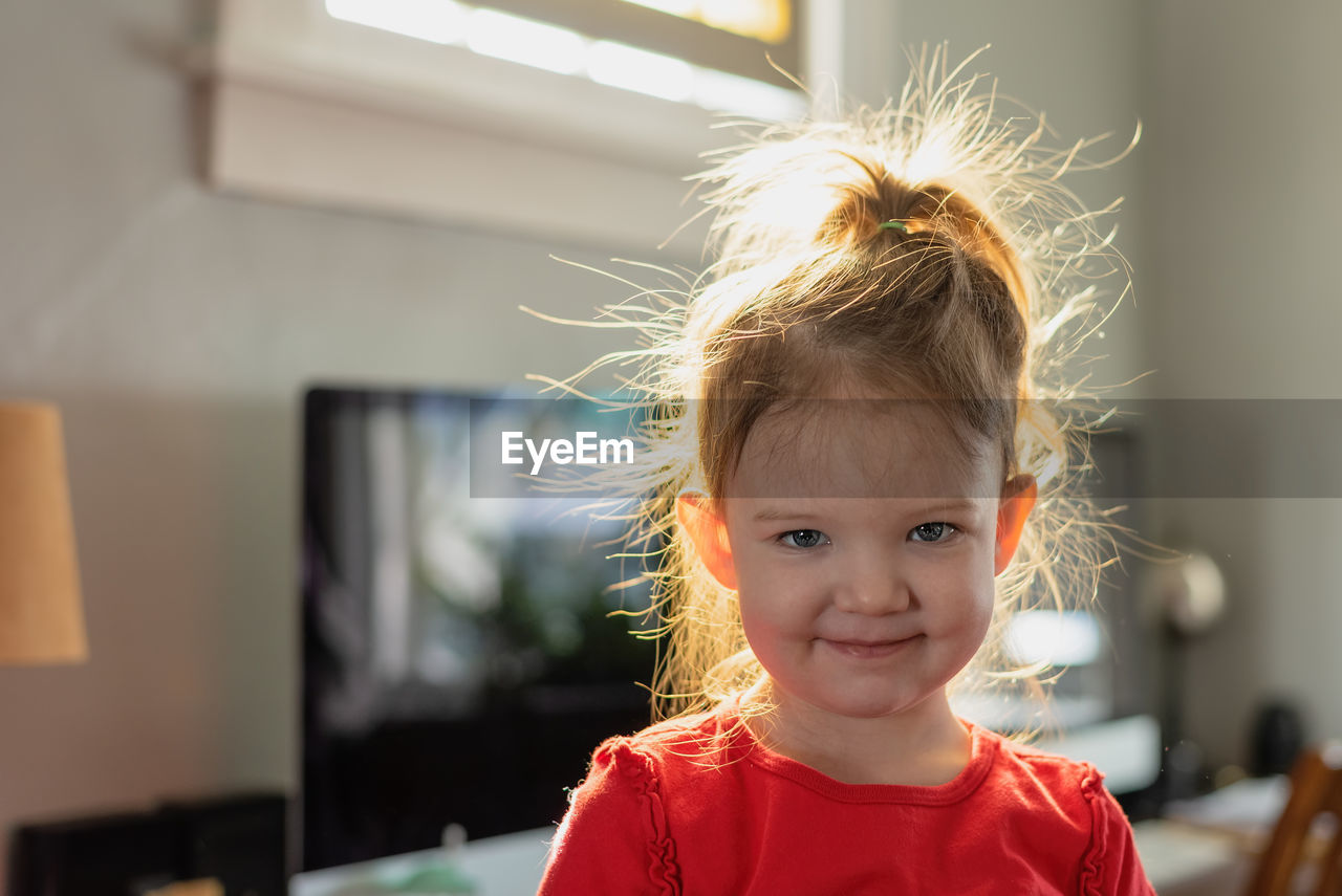 Portrait of cute girl with messy hair at home