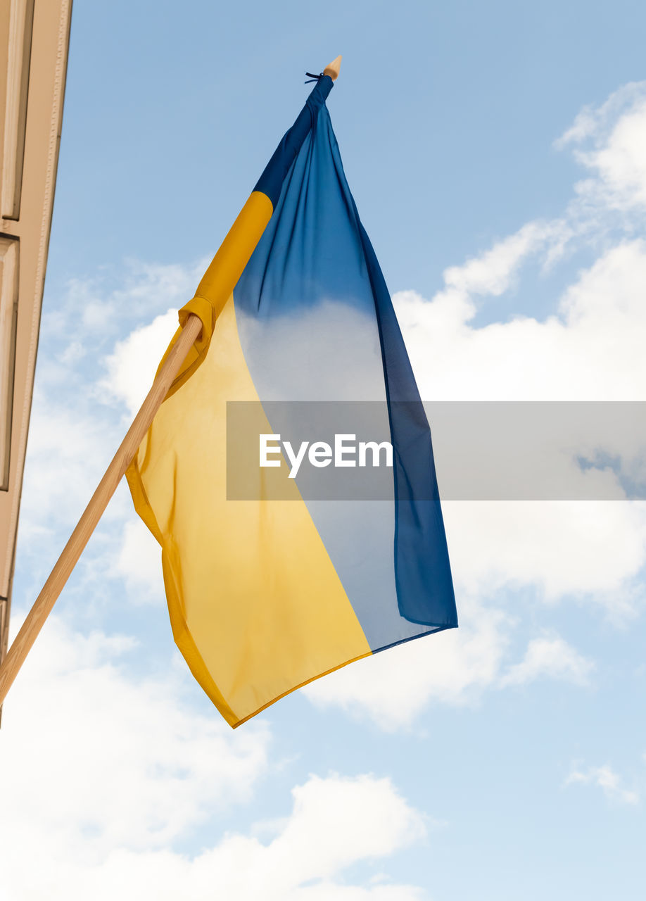 blue, sky, cloud, flag, yellow, nature, low angle view, wind, no people, environment, day, outdoors, textile, mast