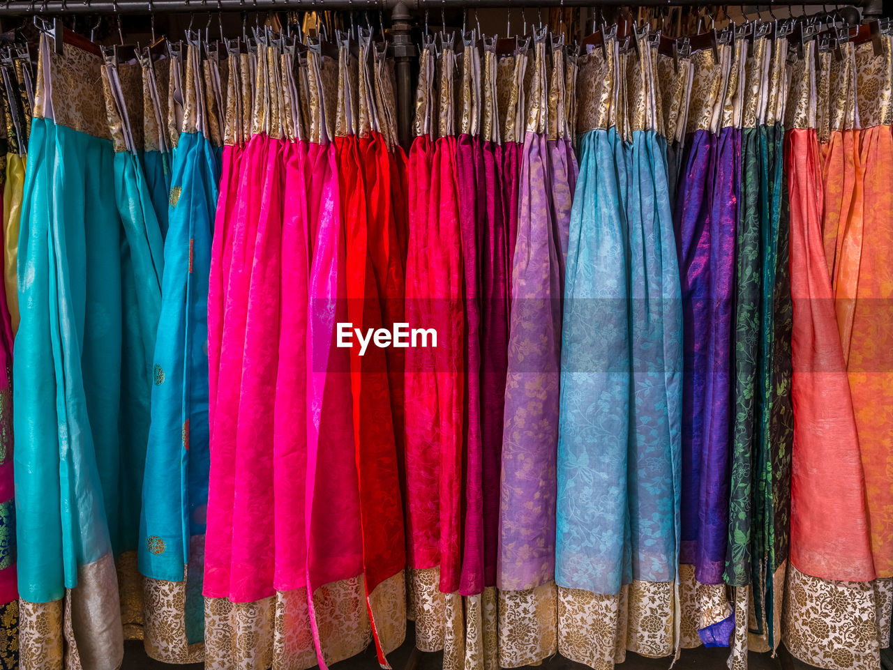 Full frame shot of multi colored womenswear hanging on rack in store