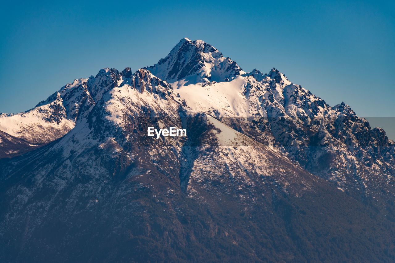 Scenic view of snowcapped mountains against clear sky