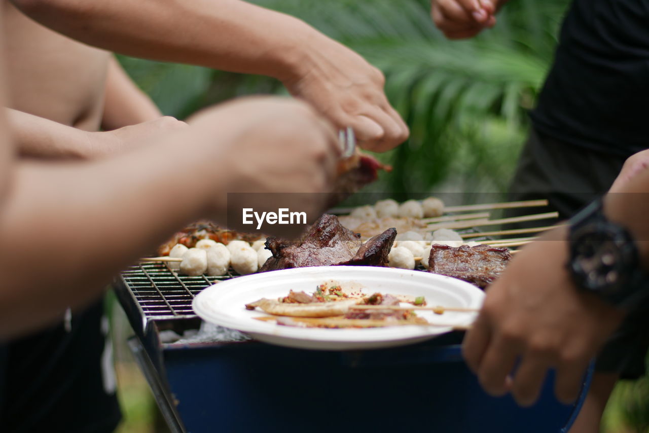 Cropped hands of people eating food