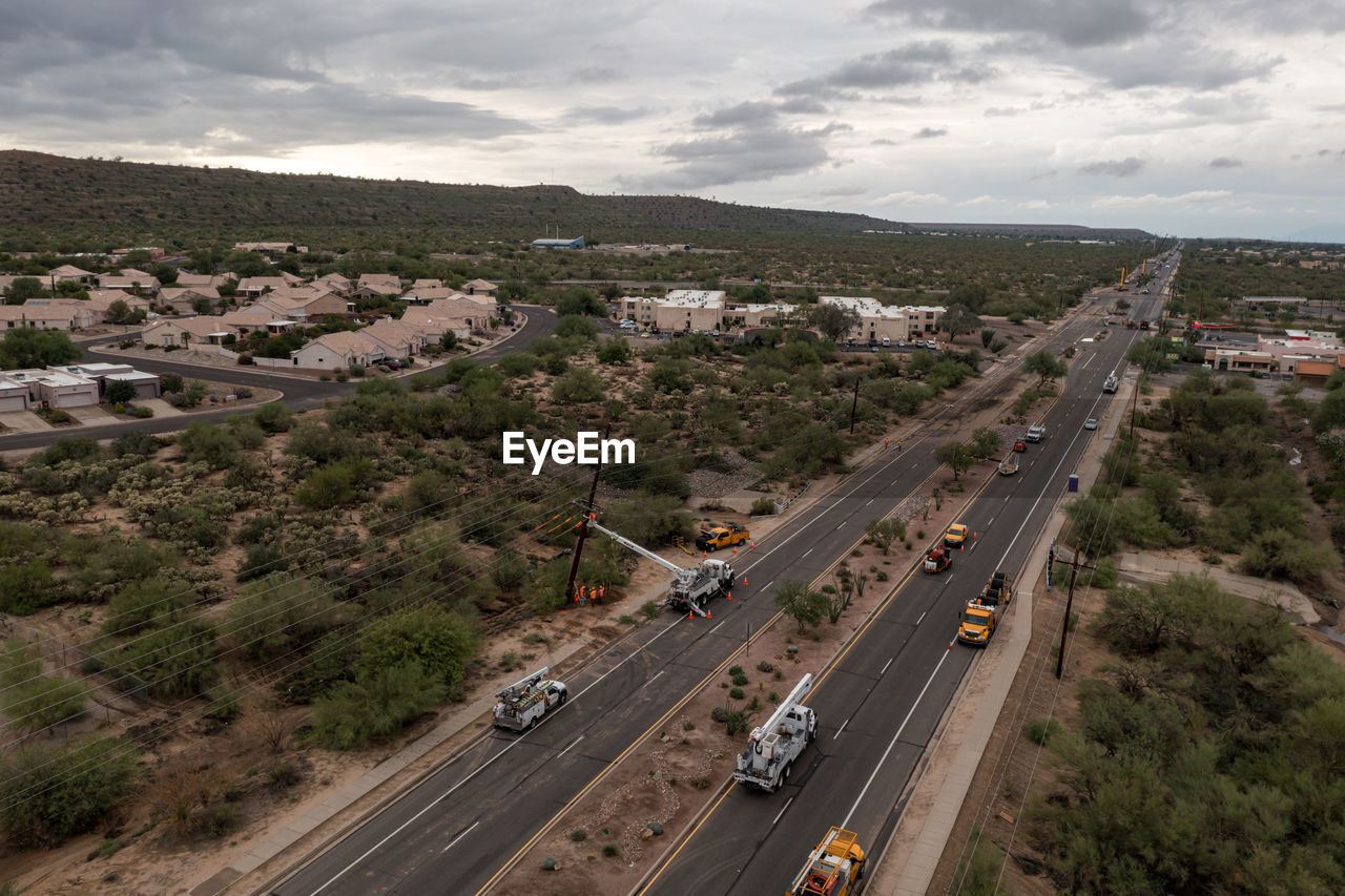 HIGH ANGLE VIEW OF VEHICLES ON ROAD AGAINST SKY