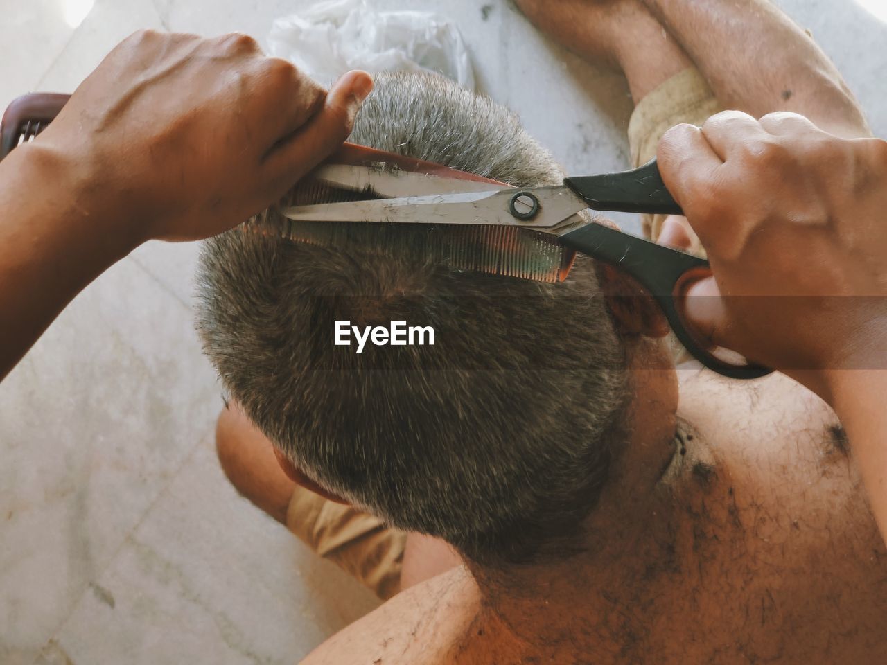 High angle view of man working/ grooming hair