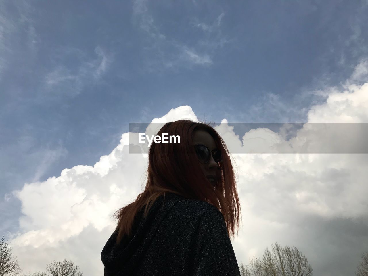 LOW SECTION OF WOMAN STANDING AGAINST SKY