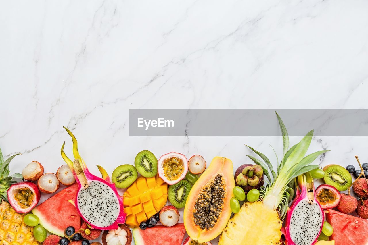 MULTI COLORED FRUITS ON TABLE AGAINST SKY