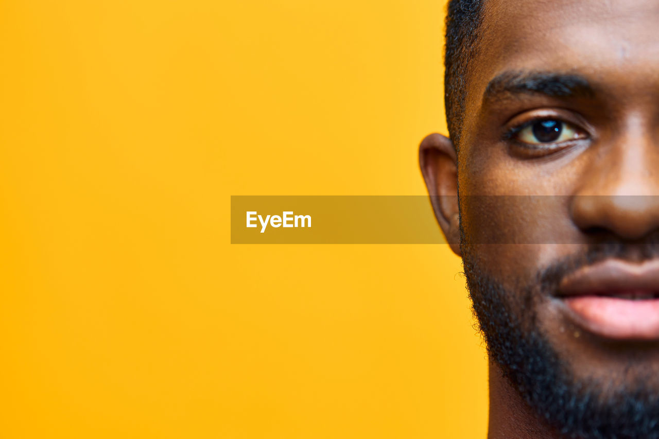 close-up portrait of man against yellow background