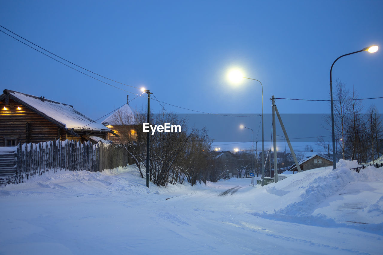 Snow covered field against sky during winter