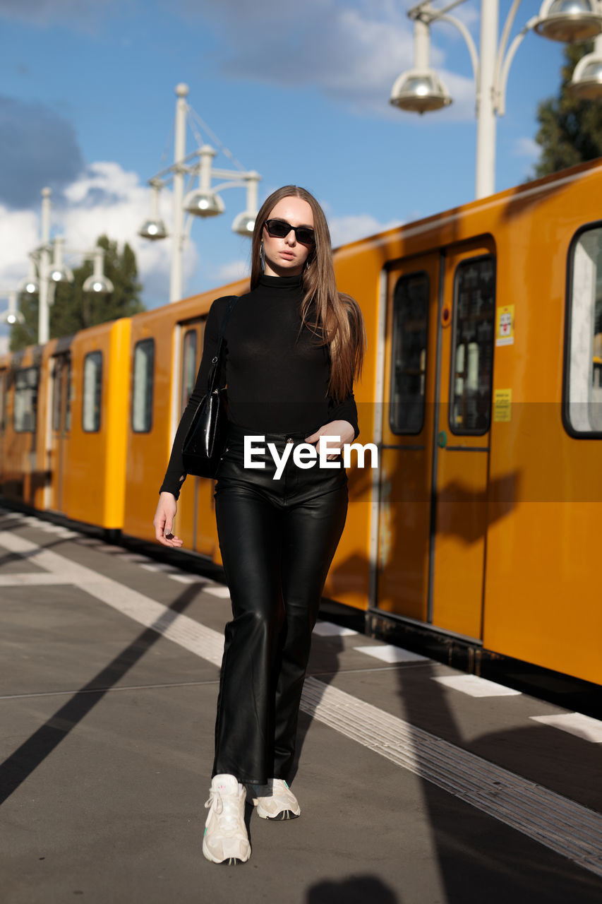 Portrait of young woman standing in train