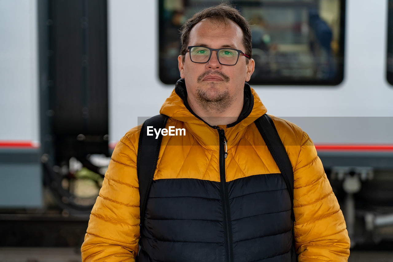 Portrait of man standing against train