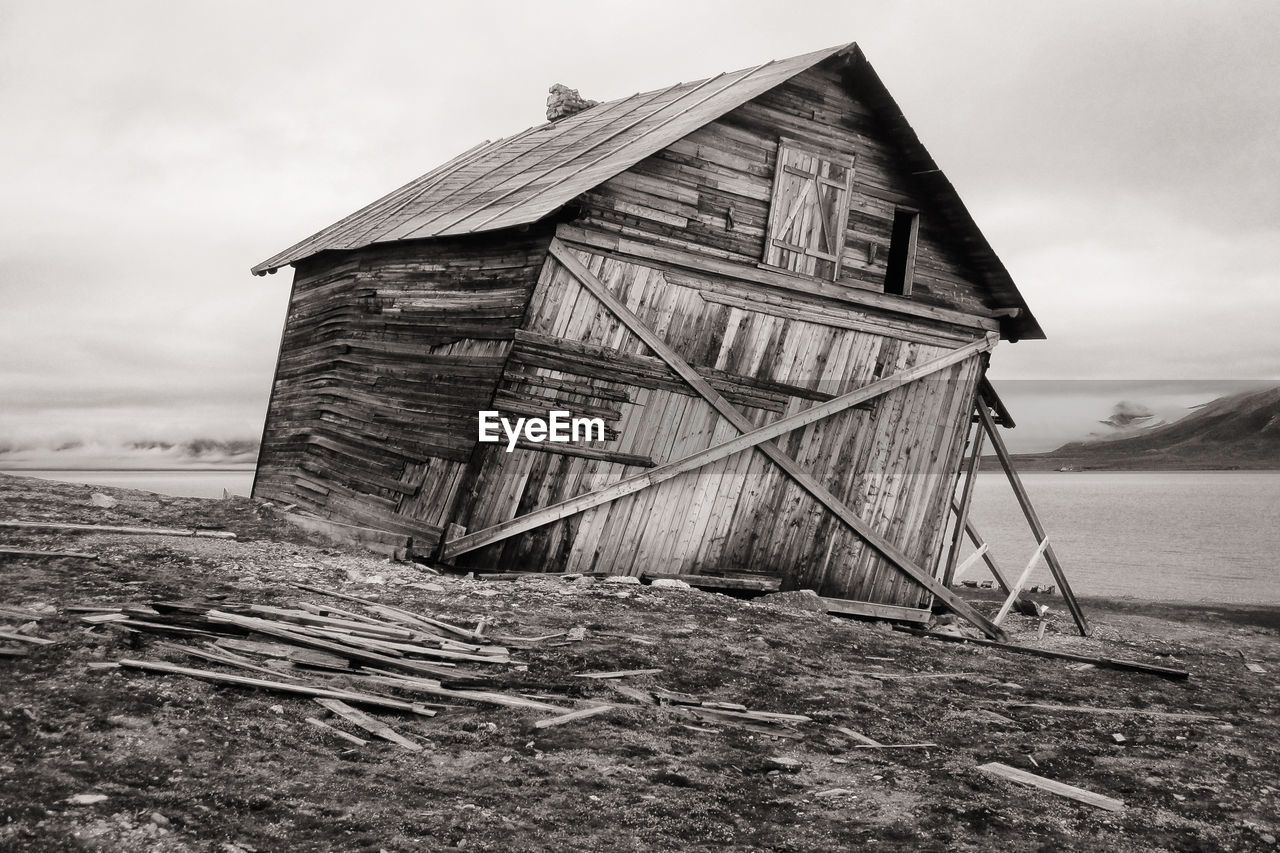 Old barn on field against sky, svalbard coast