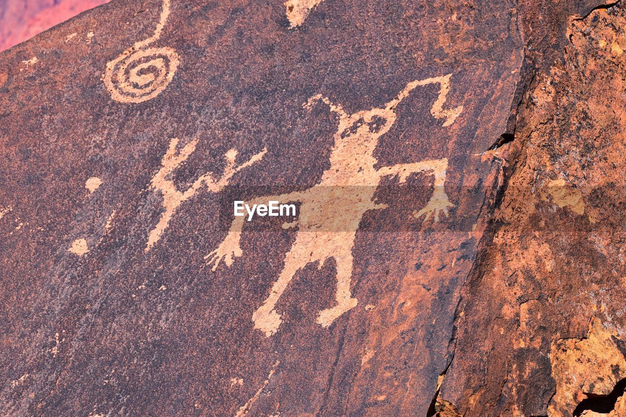 soil, no people, day, representation, creativity, rock, nature, outdoors, close-up, animal representation, communication, textured, text, wall, human representation, high angle view, geology, brown, symbol