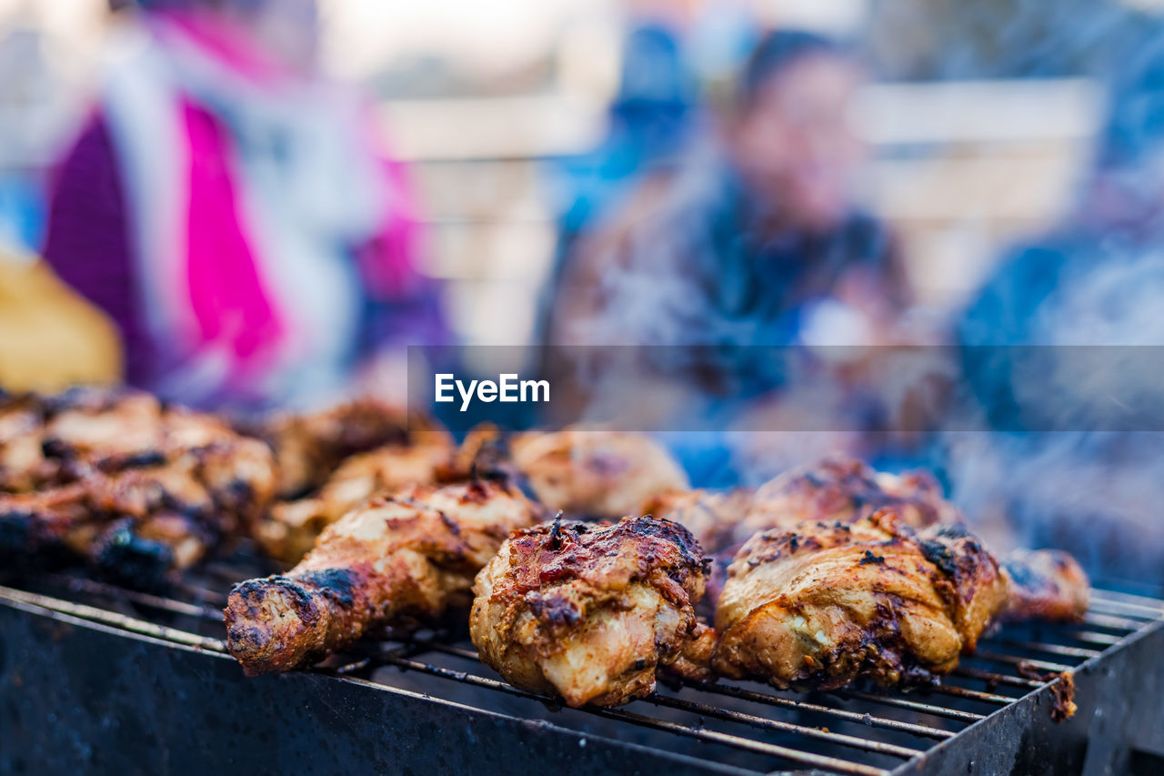 Preparing delicious smoky grilled barbecue on the charcoal flame outdoors.