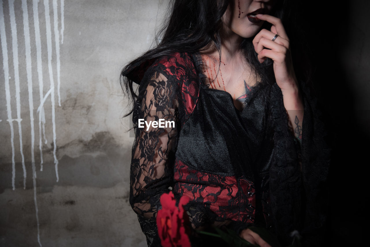 Young woman with spooky make-up against wall