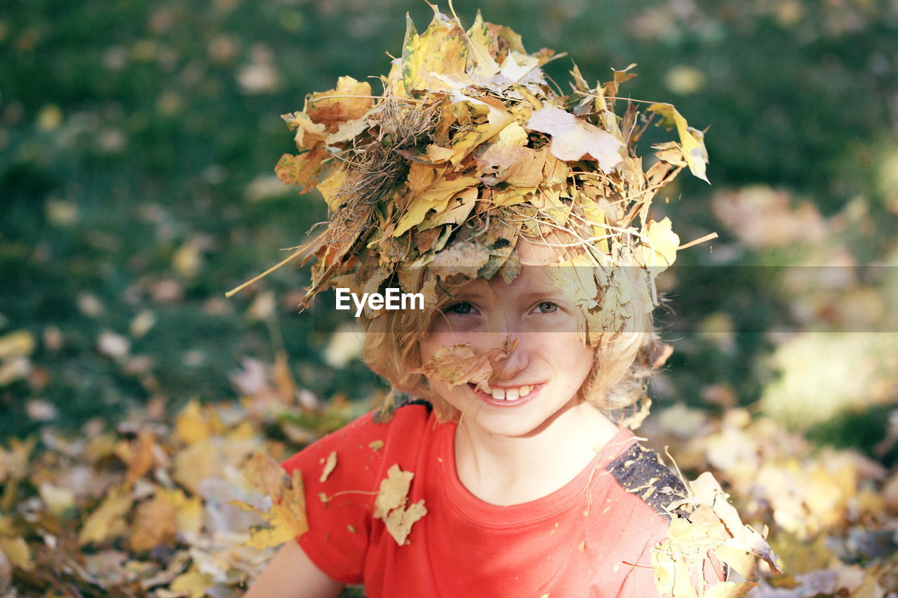 Close-up portrait of boy with leaves on head