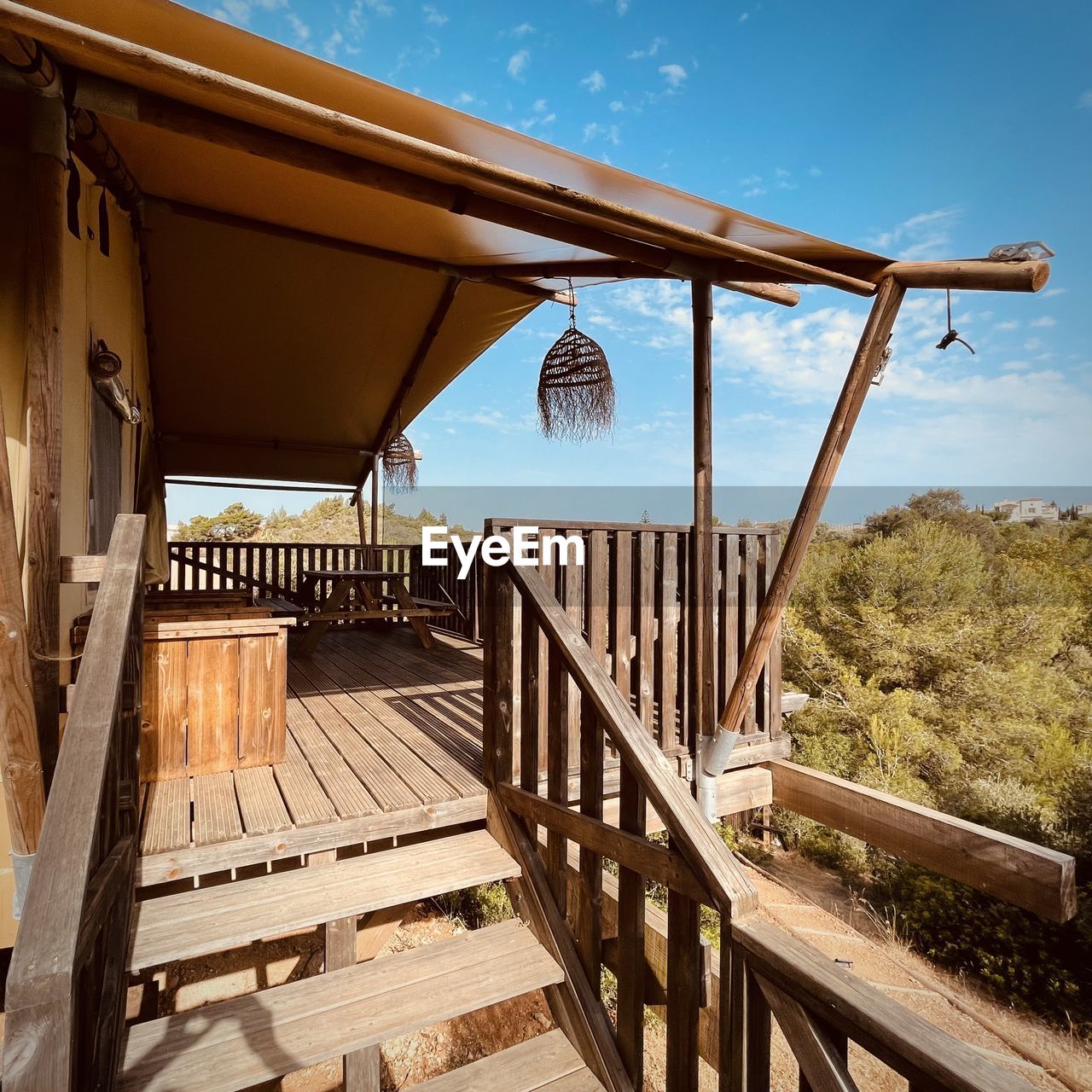 architecture, sky, built structure, nature, wood, estate, no people, home, water, railing, outdoors, travel destinations, landscape, land, building exterior, sunlight, day, travel, scenics - nature, bridge, house, tree, blue, summer, vacation, building, plant, environment, tranquility