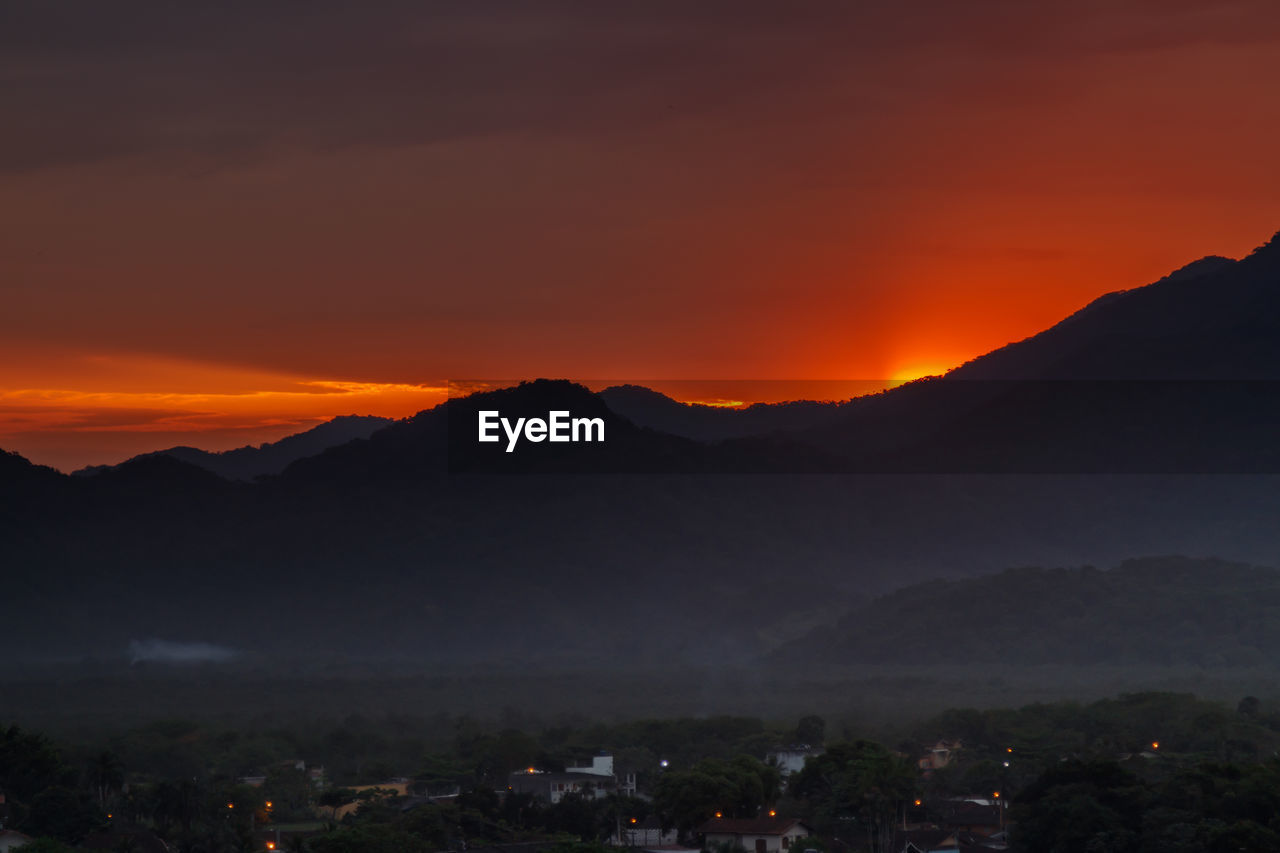 SILHOUETTE MOUNTAINS AGAINST SKY AT SUNSET