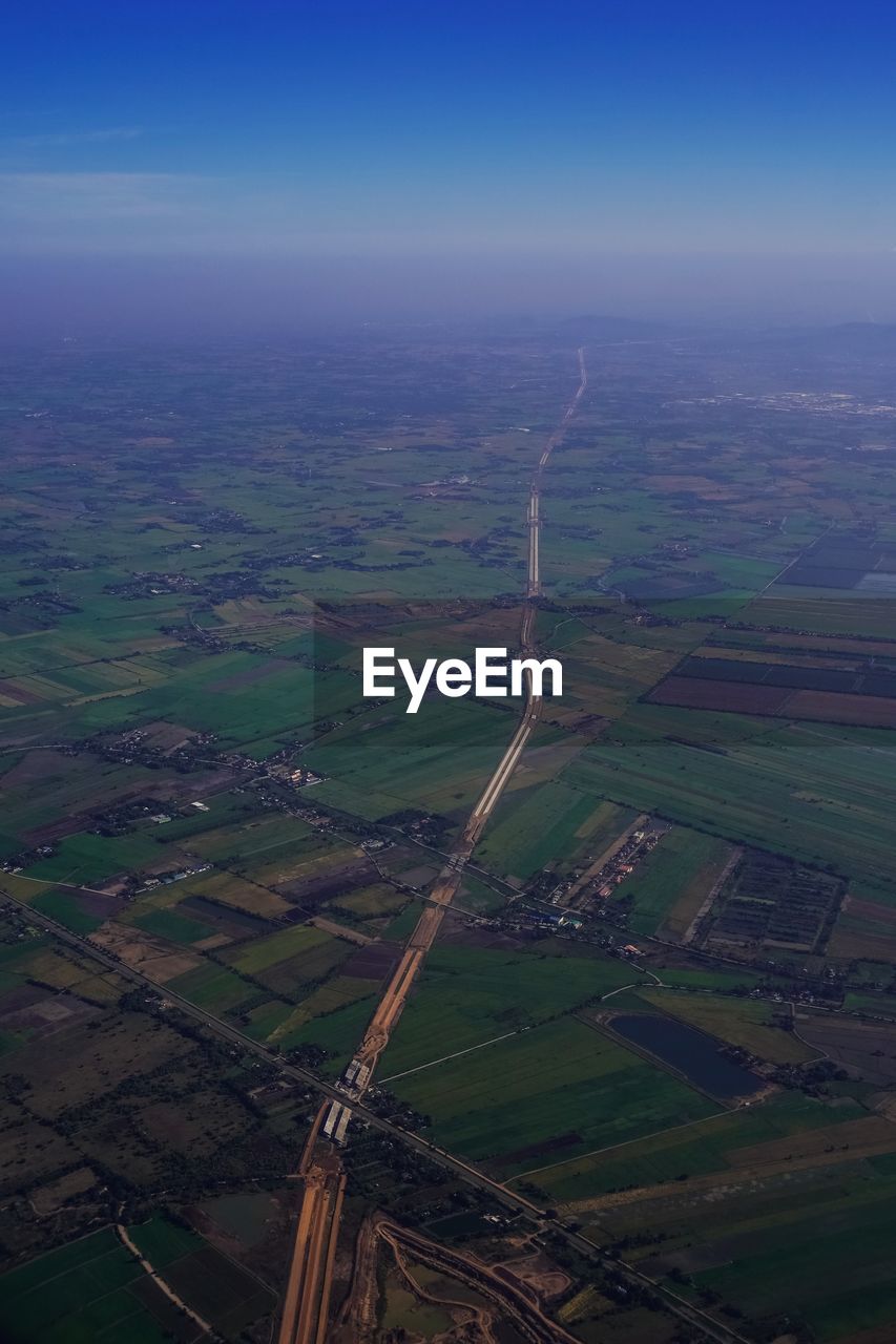 AERIAL VIEW OF AGRICULTURAL LANDSCAPE AGAINST SKY