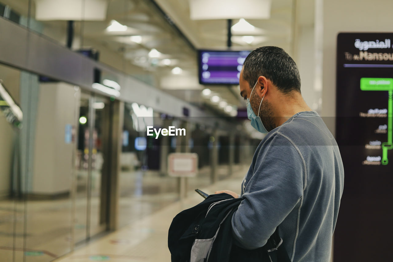 one person, adult, men, technology, indoors, side view, communication, focus on foreground, looking, business, standing, business finance and industry, person, travel, young adult, lifestyles, architecture, transportation, waist up, wireless technology, businessman