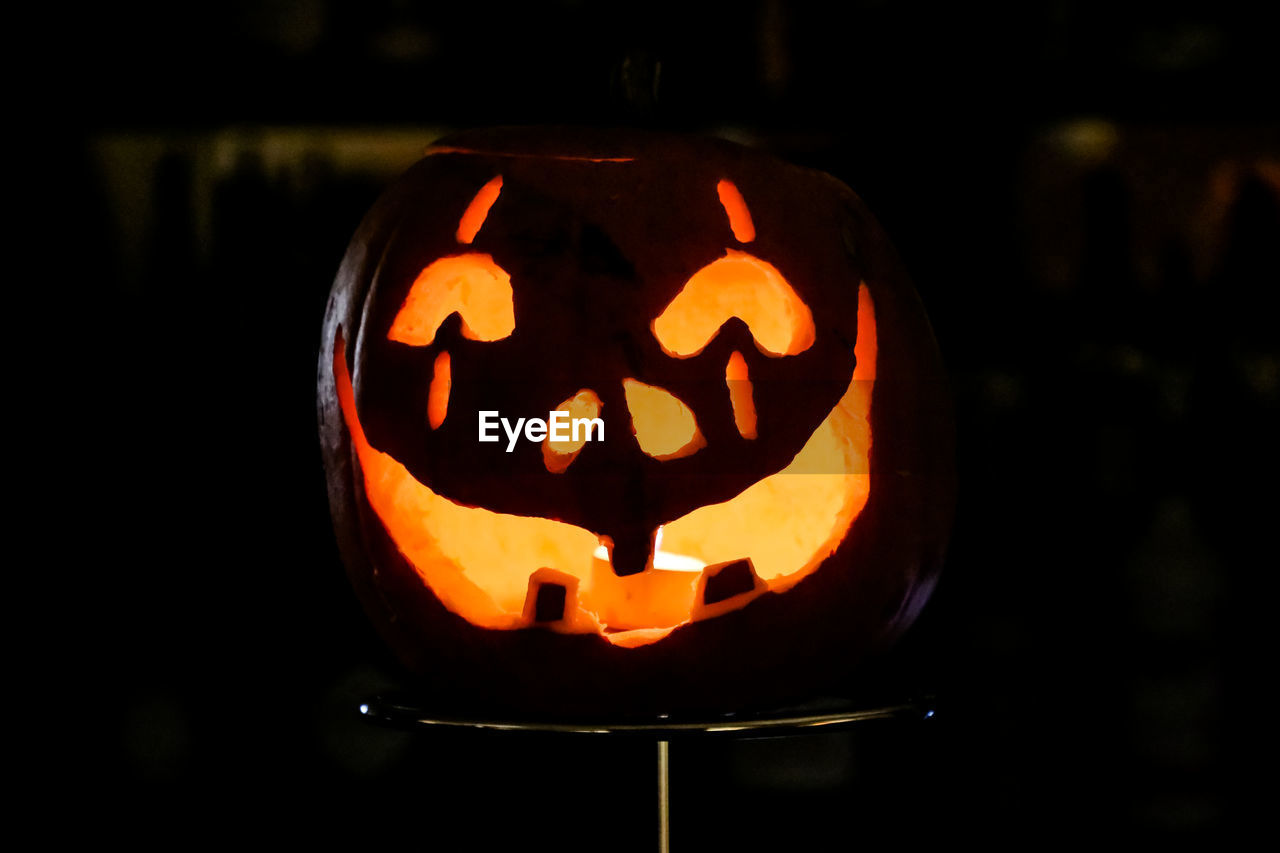 CLOSE-UP OF ILLUMINATED PUMPKIN AGAINST ORANGE LIGHT