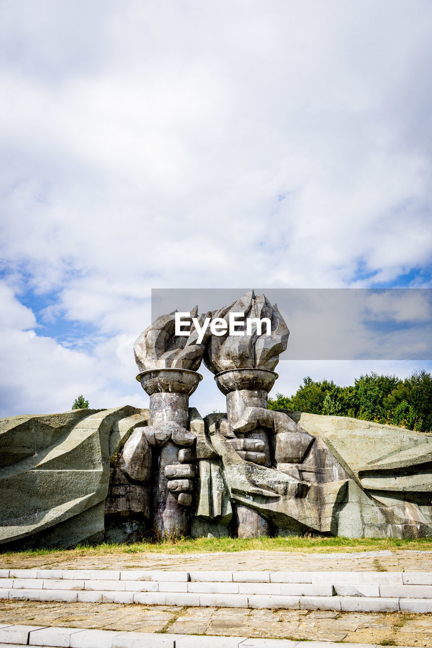 STATUE IN FRONT OF ROCK FORMATION